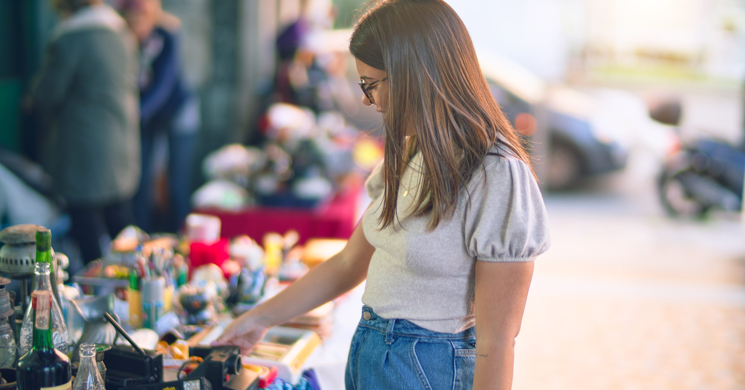 jeune femme cherchant un objet sur un stand